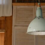 Une belle suspension verte design illuminant un salon moderne avec style et fraîcheur.