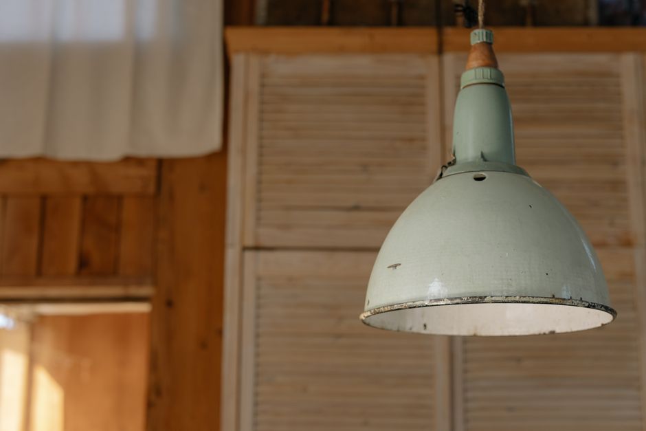 Une belle suspension verte design illuminant un salon moderne avec style et fraîcheur.